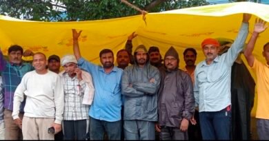 भयंकर बारिश में भी कंपनी गेट पर डटे मजदूर, 102 श्रमिकों की कार्यबहाली की मांग